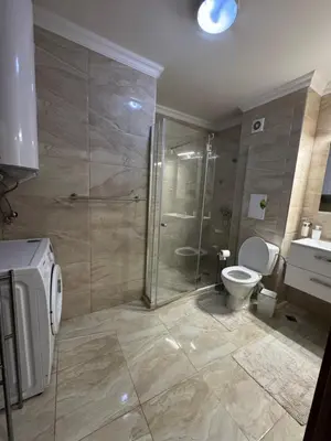 a bathroom with a shower and a toilet and a sink at Gold Coast SP apartments in Burgas City