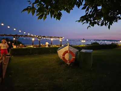 a boat sitting on the grass next to a trash can at MONASTERY Seafront Apartments in Sveti Vlas