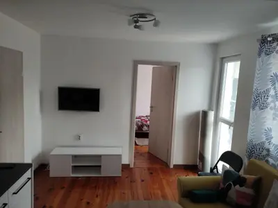 a living room with a couch and a tv on a wall at rozi in Burgas City