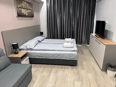 a small bedroom with a bed and a couch at Студио Комфорт Бургас Център in Burgas City