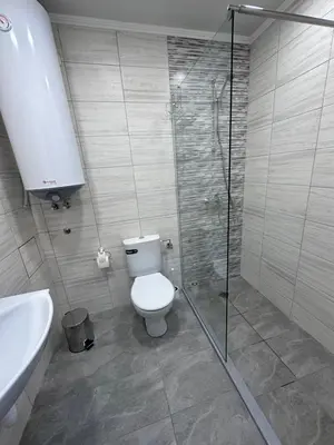 a bathroom with a shower and a toilet and a sink at Студио Комфорт Бургас Център in Burgas City
