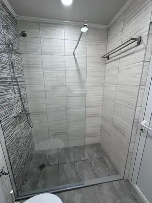 a bathroom with a glass shower with a toilet at Студио Комфорт Бургас Център in Burgas City