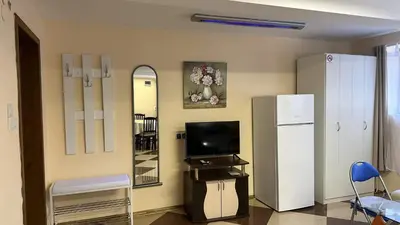 a room with a refrigerator and a tv and a mirror at Spacious Apartment in Central Burgas in Burgas City