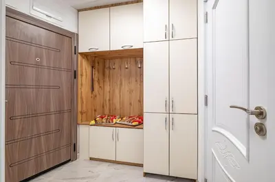 a kitchen with white cabinets and a wooden door at Boutique 1 bedroom apartment with Private Parking and Port View in Varna City