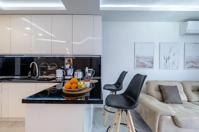 a kitchen and living room with a couch and a table at Boutique 1 bedroom apartment with Private Parking and Port View in Varna City