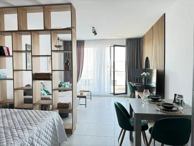 a bedroom with a bed and a dining room at Sea la Vie in Sozopol