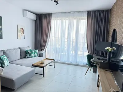 a living room with a couch and a tv at Sea la Vie in Sozopol