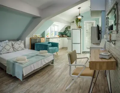 a bedroom with a bed and a table and a kitchen at Bella in Nesebar