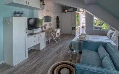 a living room with a couch and a tv at Bella in Nesebar
