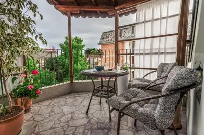 a screened in porch with chairs and a table at Bella in Nesebar