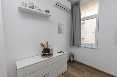 a white room with a dresser and a window at The Central House 1 in Burgas City