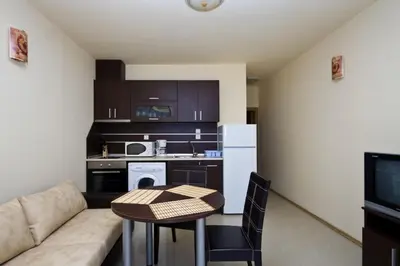 a small living room with a couch and a table at Апартаменти за гости ГАРДЪН БИЙЧ in Chernomorets