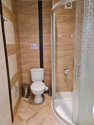 a bathroom with a toilet and a shower at Апартаменти за гости ГАРДЪН БИЙЧ in Chernomorets