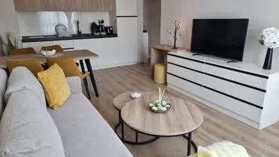 a living room with a couch and a tv and a table at Sorrento Sole Mare V&D Luxury Style Apartment in Sveti Vlas