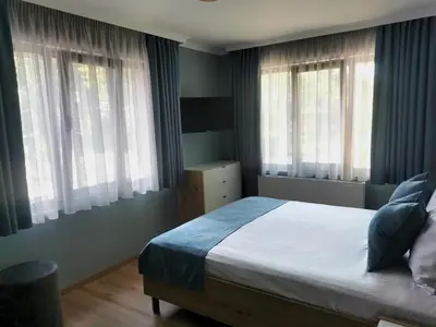 a bedroom with a bed and two windows at Timeless Sea in Tsarevo