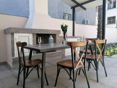 a table and chairs on a patio with a fireplace at Timeless Sea in Tsarevo