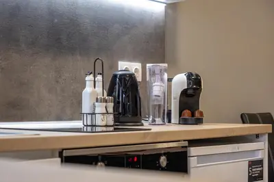 a kitchen counter with bottles and utensils on it at Apartment Linda Cosy Getaway in Varna City