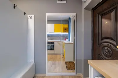 a hallway with a door to a kitchen with yellow cabinets at Apartment Linda Cosy Getaway in Varna City