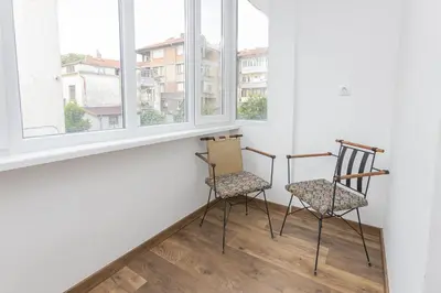 two chairs sitting in a room with windows at The Central House 2 in Burgas City
