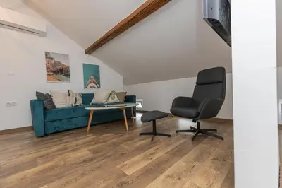 a living room with a blue couch and a chair at The Central House 3 in Burgas City