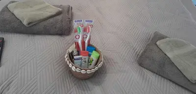 a basket of toothbrushes and toothpaste on a bed at The Central House 3 in Burgas City