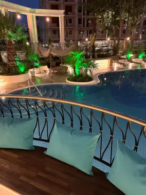 a hotel balcony with a swimming pool at night at Tranquilo Escapes in Sunny Beach