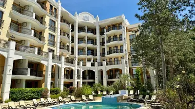 an apartment building with a swimming pool and chairs at Tranquilo Escapes in Sunny Beach