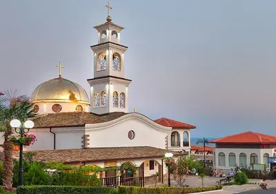 a church with a clock tower on top of it at Sea Vista Hotel in Sveti Vlas