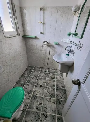 a bathroom with a green toilet and a sink at Вила Катажина - Villa Katarzyna in Sozopol