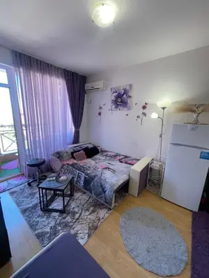 a living room with a bed and a table at Студио Sunny Day 6 Sunny beach in Sunny Beach