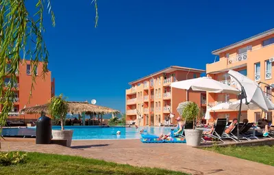 a pool at a resort with people sitting in chairs and an umbrella at Студио Sunny Day 6 Sunny beach in Sunny Beach