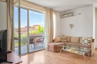 a living room with a couch and a balcony at Charming 1-Bedroom Apartment in Ravda by Flat Mаnаger in Nesebar