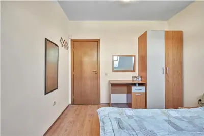 a bedroom with a bed and a desk with a mirror at Charming 1-Bedroom Apartment in Ravda by Flat Mаnаger in Nesebar