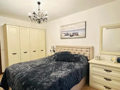 a bedroom with a bed and a dresser and a chandelier at Seaside Oasis Apartment in Lozenets