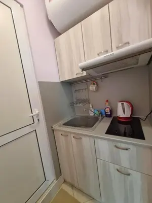 a small kitchen with white cabinets and a sink at Mateo Center in Varna City