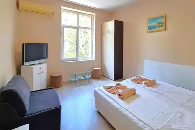 a bedroom with a large bed and a tv at Mateo Center in Varna City