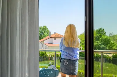 a woman is looking out of a window at Azur properties 7 in Shkorpilovtsi