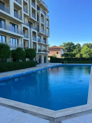 a large blue swimming pool in front of a building at Azur properties 7 in Shkorpilovtsi
