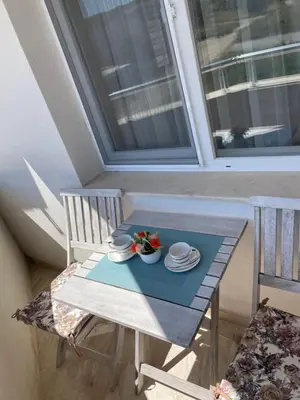 a table with two chairs and a plate of food on it at Garmanovi Apartment in Sozopol, with free parking in Sozopol