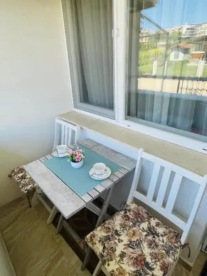 a table and two chairs and a table and a window at Sunset studio in Sozopol, with free parking in Sozopol