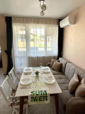 a living room with a table and a couch at Sunset studio in Sozopol, with free parking in Sozopol