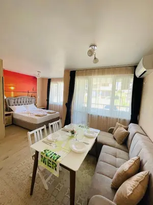 a living room with a couch and a table at Sunset studio in Sozopol, with free parking in Sozopol