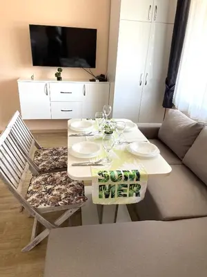 a living room with a table and a couch at Palms Studio in Sozopol, with free parking in Sozopol