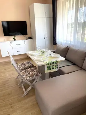 a living room with a table and a couch at Palms Studio in Sozopol, with free parking in Sozopol