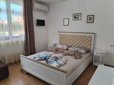a bedroom with a large bed with a large window at Стаи за гости Гергана град Созопол in Sozopol
