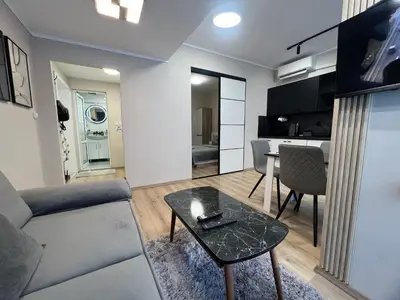 a living room with a couch and a table at Varna central apartment with parking for normal to middle sized cars in Varna City