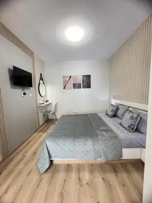 a bedroom with a large bed and a desk at Varna central apartment with parking for normal to middle sized cars in Varna City