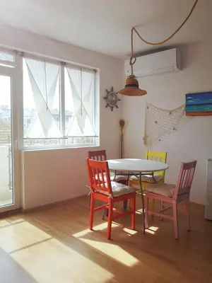 a dining room with a table and chairs and a window at Astell Superior Studio in Burgas City