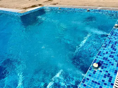 a large blue swimming pool with a blue tile floor at Апартамент Vip Vision Studio LUX in Sunny Beach