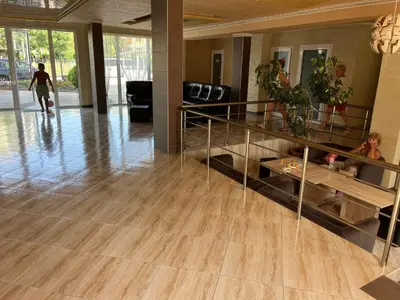 a living room with a wooden floor and a staircase at Апартамент Vip Vision Studio LUX in Sunny Beach
